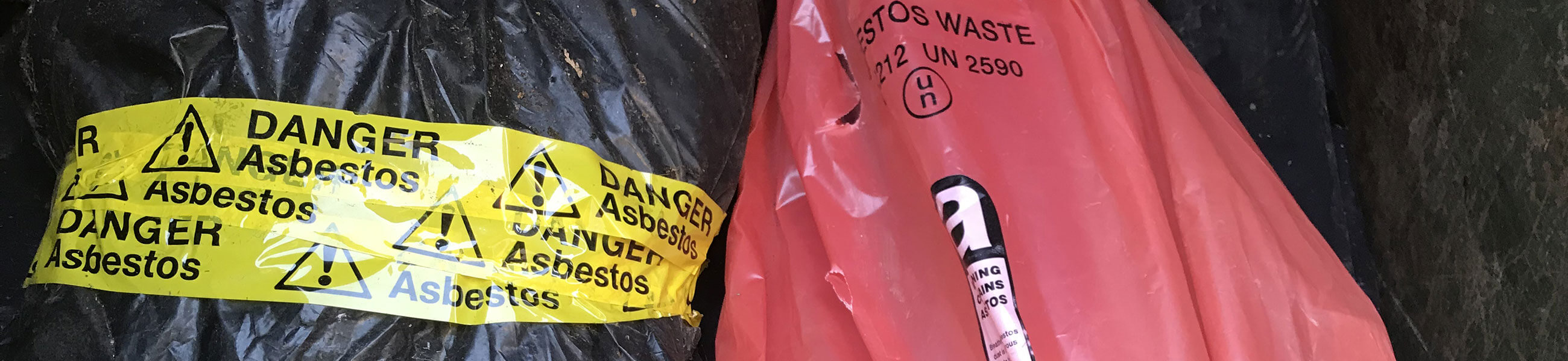 Double-wrapped and sealed asbestos waste with warning tape, ready for legal collection